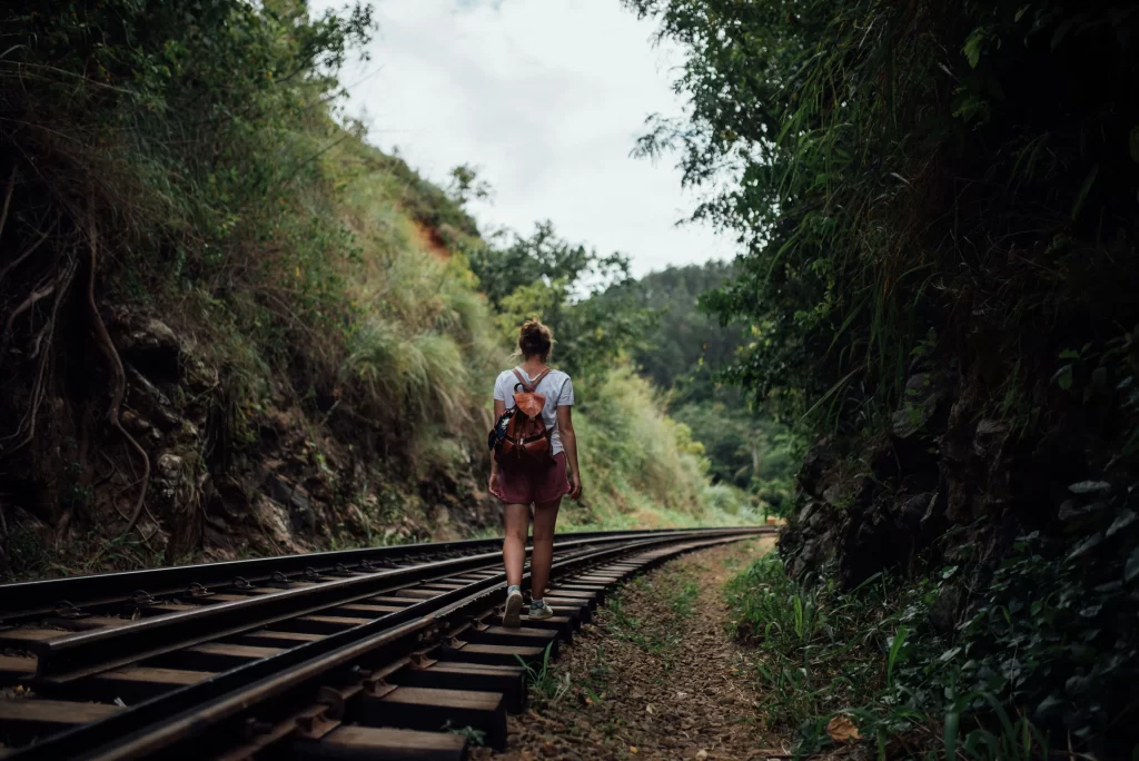 Ella tour package Sri Lanka - hiker at the summit of Little Adam's Peak overlooking tea valleys